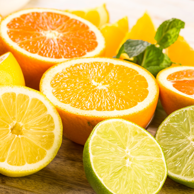 Aufgeschnittene Zitrusfr&uuml;chte: Grapefruit, Orange, Zitrone, Limette und Minzbl&auml;tter auf Holzuntergrund