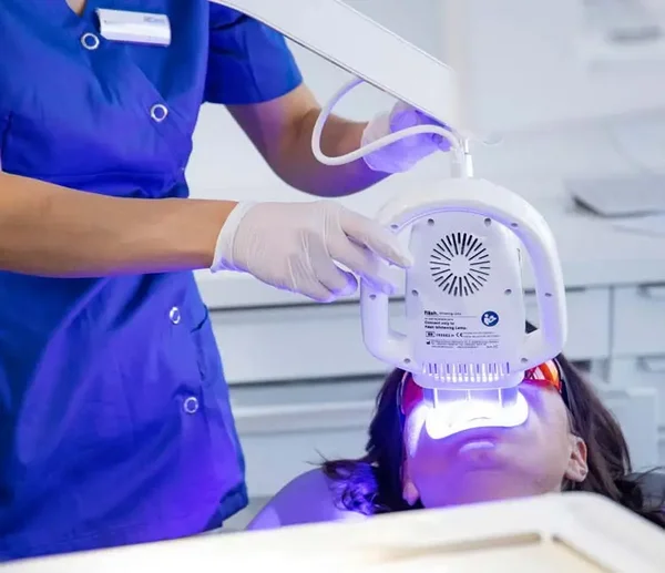 Prophylaxeassistentin führt ein Bleaching bei einer Patientin durch