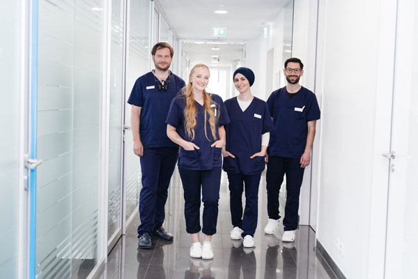 Gruppe Oralchirurgen steht im Flur des Zahnzentrums
